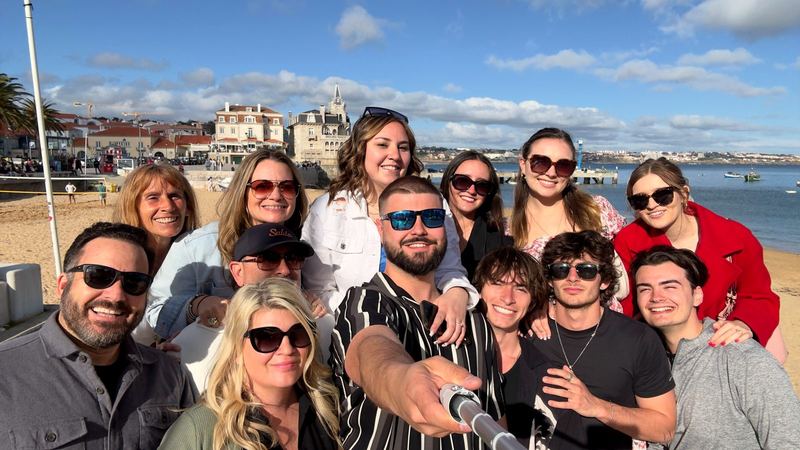 Artie, April, and a big group of friends on a seaside promenade