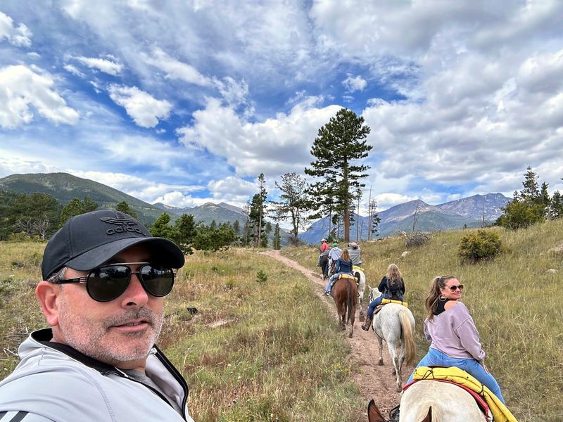 Artie on horseback leading the family up a mountain trail