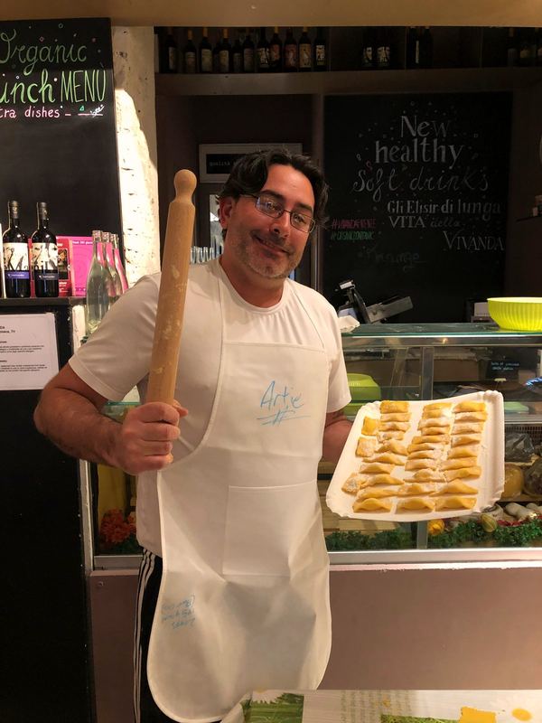 Artie in an apron holding a tray of fresh handmade pasta